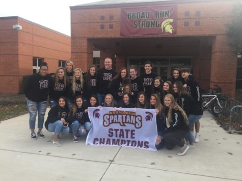 The 2018 Varsity Cheer Team holding their state championship trophy and banner.