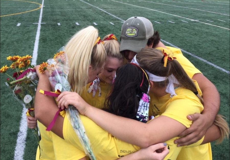 The five Broad Run Varsity Field Hockey Seniors, Madison Guyton, Julia Kasban, Varisha Patel, Madie Hricik and team manager Jacob Foster, share group hug after being escorted onto the field by family and their teammates.