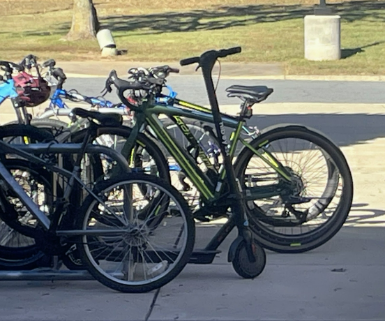 An electric scooter parked among the bikes outside of Broad Run